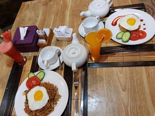 The Lucky Cottage في نوسا ليمبونغان: طاولة عليها طبقان من البيض والخضراوات والمشروبات