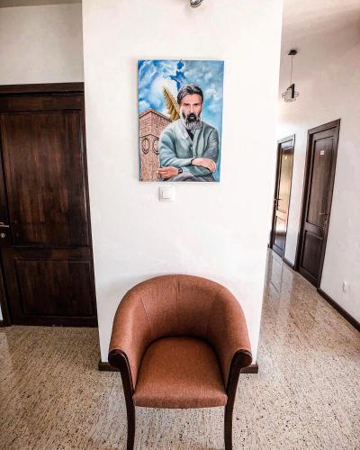 a chair in a room with a painting on the wall at Pensiunea Casa Hortopan in Târgu Jiu