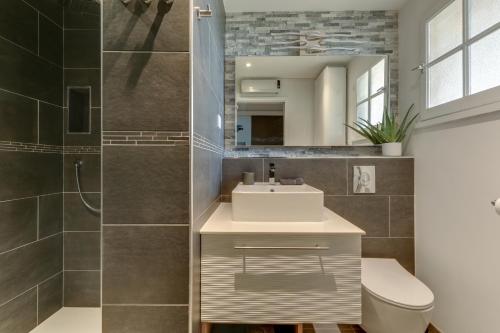 a bathroom with a sink and a toilet and a mirror at LE HAMEAU DES PINS in Saint-Raphaël