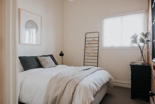 a bedroom with a white bed and a window at Apartments on Belmore -The Ferguson in Yarrawonga