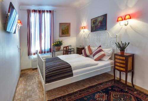 a bedroom with a white bed in a room at Logis Hôtel Villa Victorine in Nice