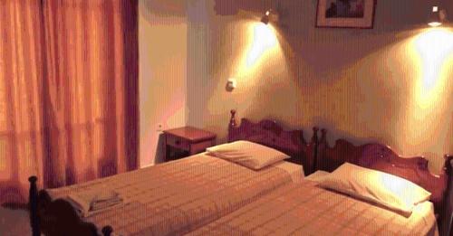 een slaapkamer met een bed met verlichting aan de muur bij Orama Hotel in Sígrion