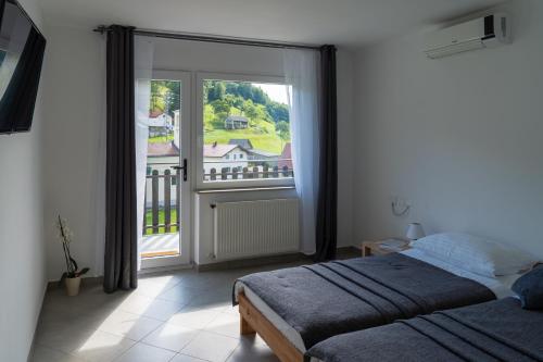 a bedroom with a bed and a large window at The FOXhouse in Tolmin