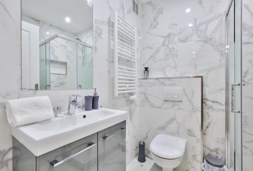 une salle de bain blanche avec un lavabo et des toilettes dans l'établissement 52 - Urban Collection Grands Boulevards, à Paris