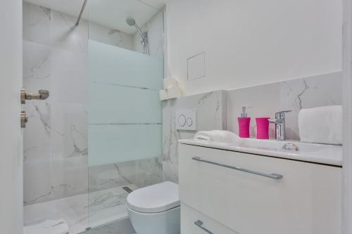 une salle de bain blanche avec des toilettes et un lavabo dans l'établissement 86 - Urban Charming Apartment, à Paris