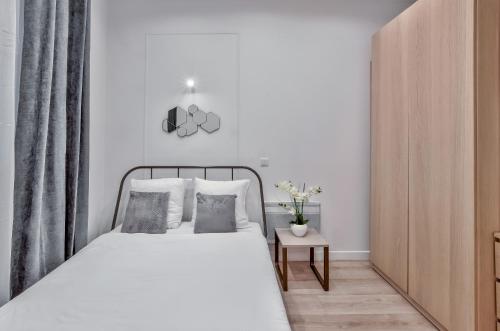 ein weißes Schlafzimmer mit einem Bett und einem Tisch in der Unterkunft 35 - Urban Montmartre in Paris