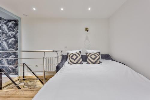 une chambre avec un lit blanc avec deux oreillers dans l'établissement 86 - Urban Charming Apartment, à Paris