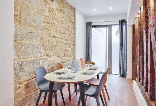 d'une salle à manger avec une table, des chaises et un mur en briques. dans l'établissement 52 - Urban Collection Grands Boulevards, à Paris