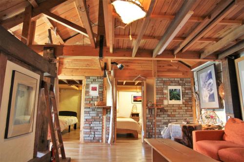 a living room with a couch and a bedroom at Gallery Stay Kitashajin in Higashikawa