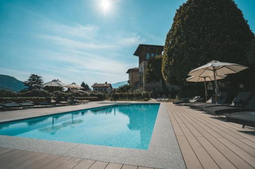 a swimming pool with chairs and an umbrella at Villa Vitali - Bellagio in Bellagio