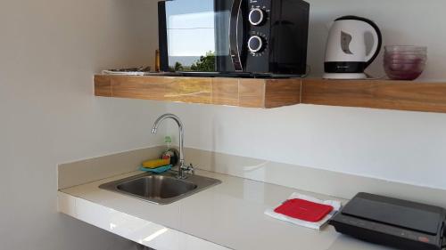 a kitchen counter with a sink and a microwave at Italy Condotel Darasa in Tanauan