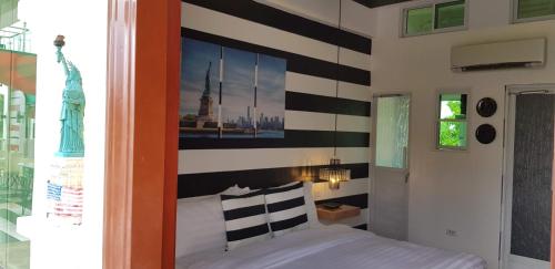 a bedroom with a striped wall with a bed at Italy Condotel Darasa in Tanauan