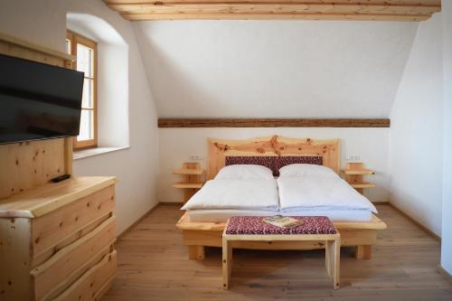 Schlafzimmer mit einem Bett, einem TV und einem Tisch in der Unterkunft Ferienhaus Almruhe in Schwanberg