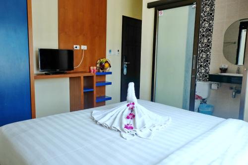 a white bed with a towel on top of it at Calypso Patong Hotel in Patong Beach