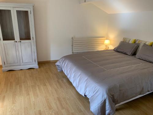 a bedroom with a large bed and a door at Montaillon Gîte in Mougon