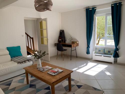 un salon avec un canapé et une table dans l'établissement Montaillon Gîte, à Mougon