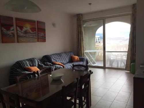 sala de estar con sofá y mesa de cristal en New and airy apartment in Marsalforn, en Żebbuġ
