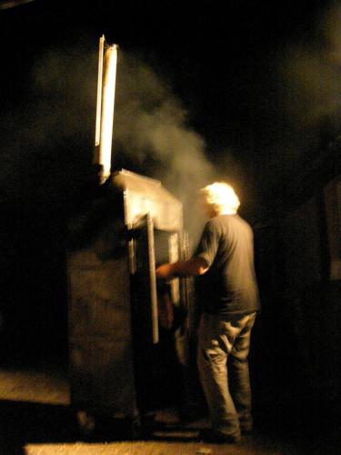 a man standing in front of a train at night at Cabin Resort in Moshav Ramot