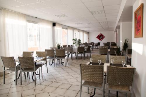 - une salle à manger avec des tables, des chaises et des fenêtres dans l'établissement Lodges Méditerranée, à Vendres-Plage