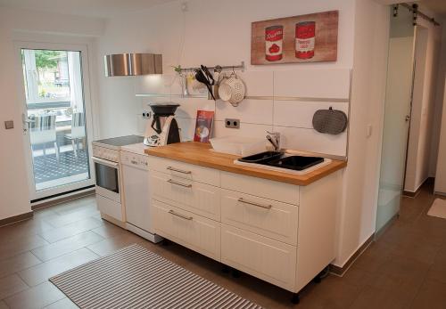 uma cozinha com um lavatório e um fogão forno superior em Ferienwohnung Sonnentau 2 em Holzminden