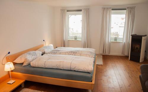 1 dormitorio con 1 cama y 2 ventanas en Ferienwohnung Sonnentau 2 en Holzminden