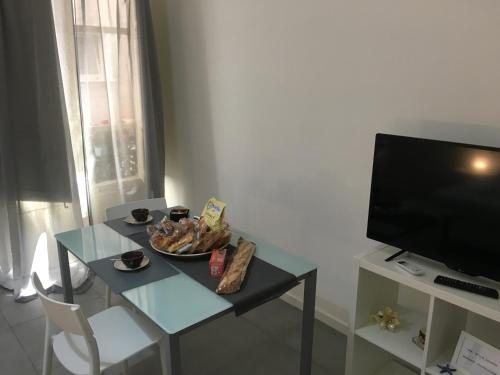 een woonkamer met een tafel en een televisie bij FREE FLAT in Catania
