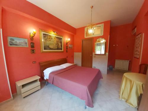 a bedroom with red walls and a bed and a table at B&B Babri Simim Taj in Rome