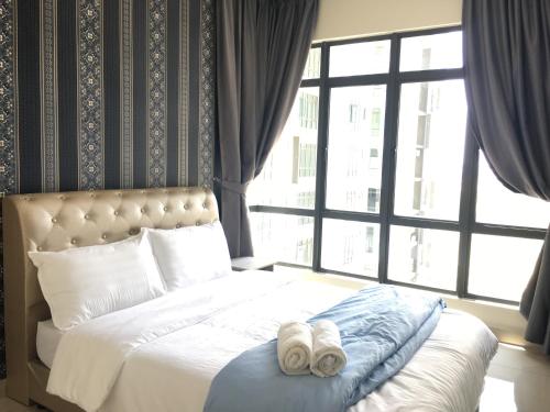 ジョホールバルにあるARC Austin hill Apartmentのベッドとタオル2枚のある寝室