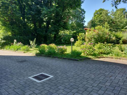 a garden with flowers and a grate in the ground at Il Gelsomino in Villa Guardia