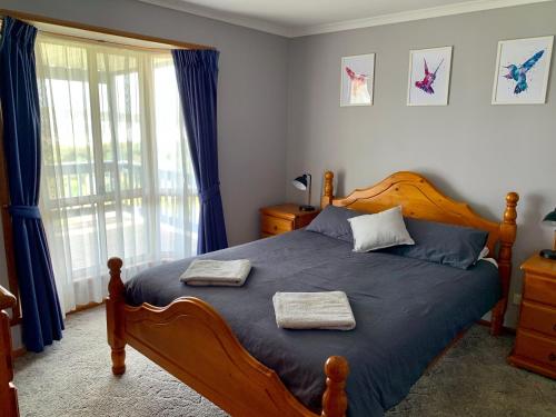 a bedroom with a wooden bed with two towels on it at Sunny Brae in Emu Bay