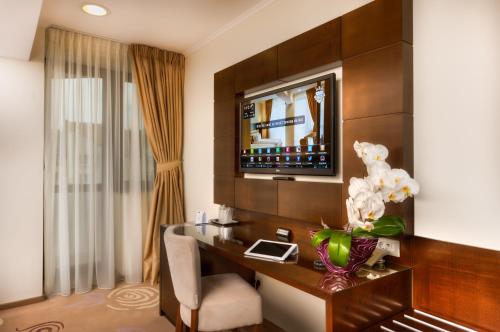 a hotel room with a desk and a television at Grand Hotel Coroana in Bistriţa