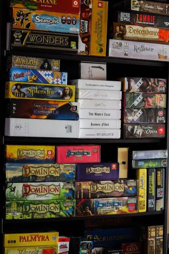 a shelf filled with different types of board games at La Malinette B&B, calme et authenticité in Mâlain