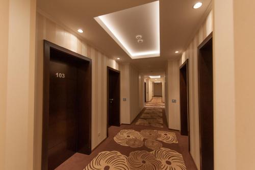 a corridor of a hotel with a hallway with a door at Grand Hotel Coroana in Bistriţa