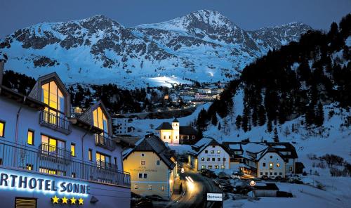 a town in the mountains at night with snow covered mountains at Apparthotel Sonne in Obertauern