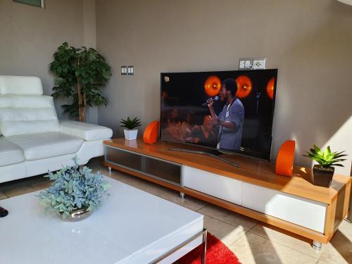a living room with a large flat screen tv at Franklin L Apartment in Johannesburg