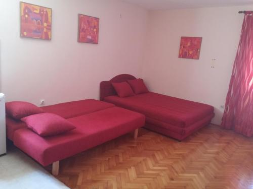 salon z 2 czerwonymi kanapami i kanapą w obiekcie Stari Grad Studio Apartment w mieście Herceg Novi