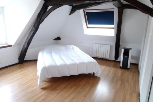 une chambre avec un lit blanc dans un grenier dans l'établissement Gîte Valentin, à Dompierre-sur-Besbre