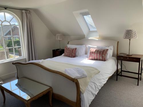a bedroom with a white bed and a window at The Bothy in Pewsey