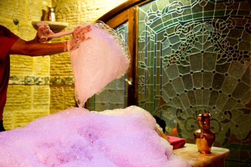 a person is making a pink object in a bathroom at Oriental Rivoli Hotel & Spa in Sharm El Sheikh