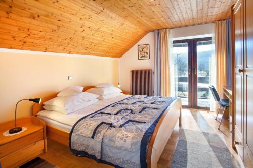 a bedroom with a bed with a wooden ceiling at Lake Bled Apartment Marjetka in Bled