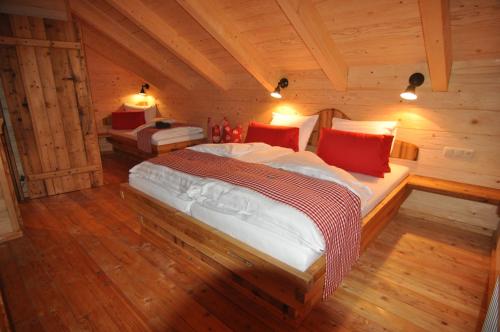 ein Schlafzimmer mit einem Bett in einer Holzhütte in der Unterkunft Jörgnerhaus in Kals am Großglockner