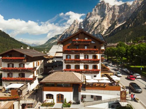 Vistas a una ciudad con una montaña en el fondo en FIORI Dolomites Experience Hotel en San Vito di Cadore