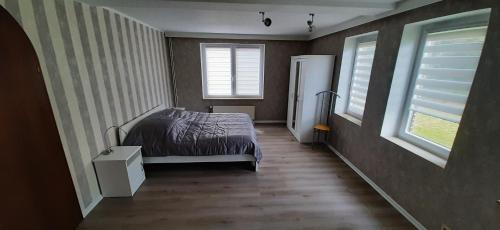 ein Schlafzimmer mit einem Bett und zwei Fenstern in der Unterkunft Funnys Deichblick in Butjadingen