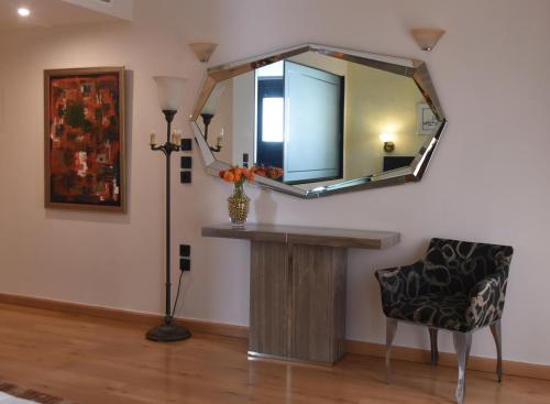 a living room with a mirror and a chair at Villa Orion Hotel in Athens