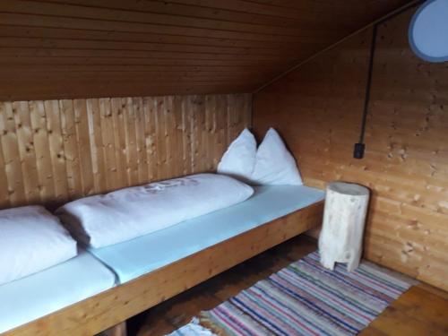 a room with two beds in a wooden cabin at Unterniggleralm in Thurn