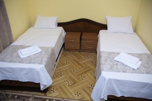 two beds in a room with white sheets and towels at Red Hotel Yerevan Center in Yerevan