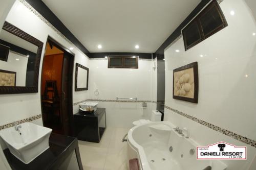 a bathroom with a sink and a toilet and a tub at Danieli Resort in Hua Hin