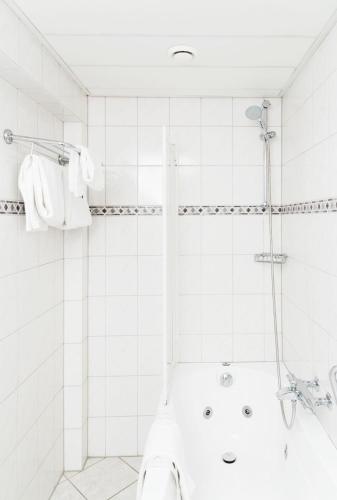 a white bathroom with a shower and a tub at Hotel 't Paviljoen in Rhenen