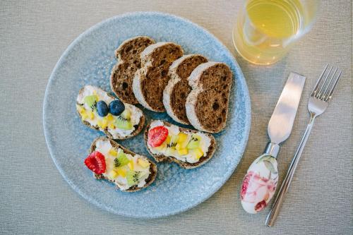 a blue plate with toast with fruit on it at NUMA HOTEL in Numana