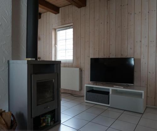 a living room with a flat screen tv and a tv stand at Ferienhaus am Schönbuchrand in Herrenberg